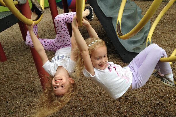 Zwei Mädchen im Kindergartenalter auf einem Klettergerüst