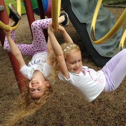Zwei Mädchen im Kindergartenalter auf einem Klettergerüst