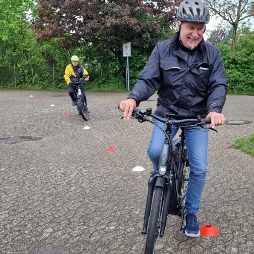 Auf dem Bild befinden sich zwei Fahrradfahrer, die mit ihrem Pedelec einen Parcours befahren.